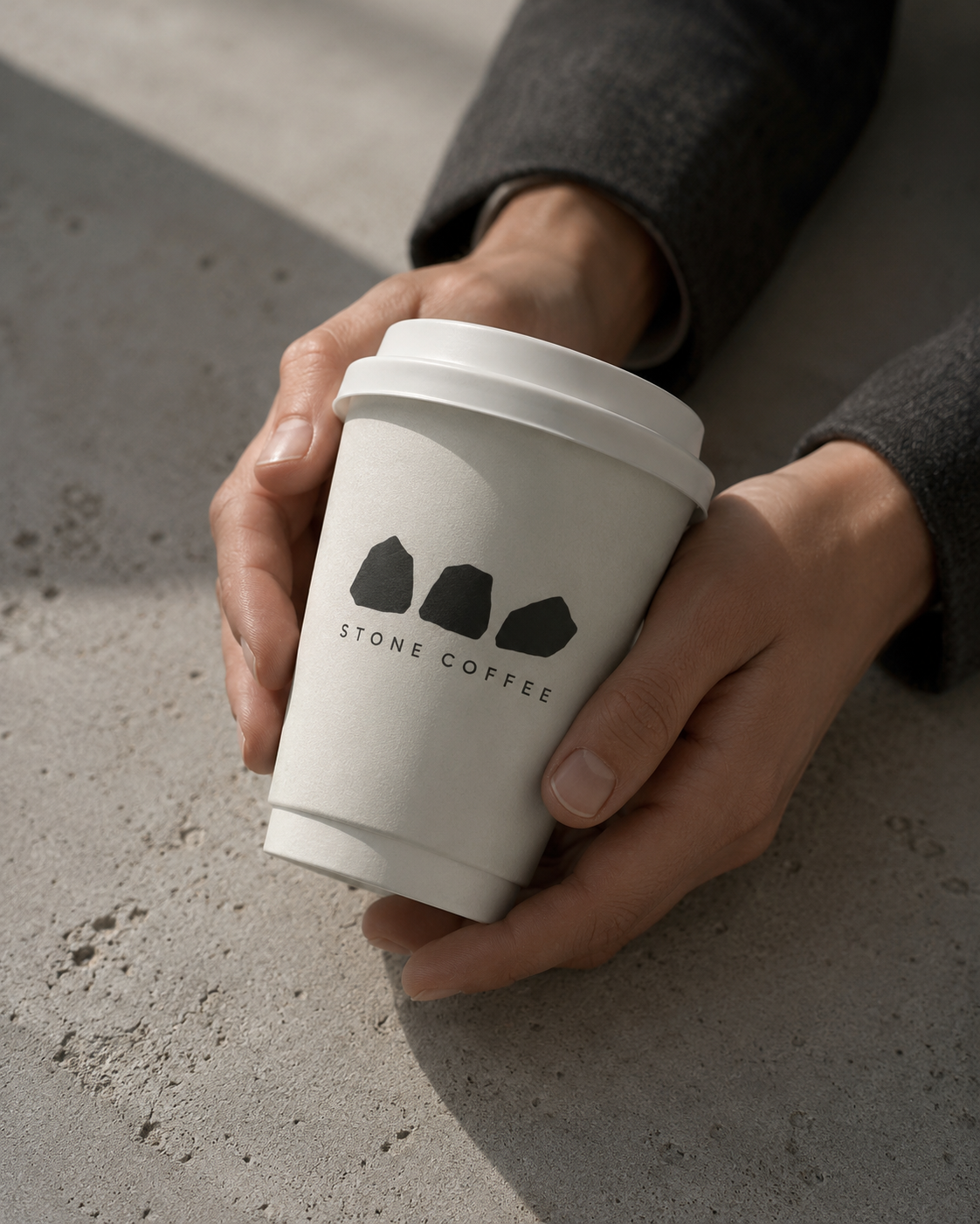Stone Coffee branded paper cup held in hands